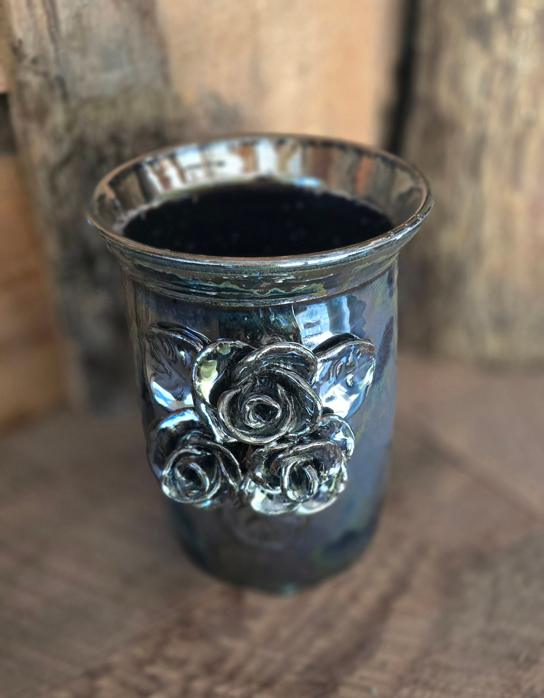 This photo is of our 8" Metalic Glazed Custom made vase. It features 3 lovely hand carved roses on the front and has a flanged lip.