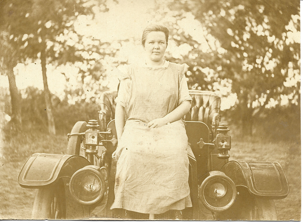 My great grandmother perched upon the hood of her car.