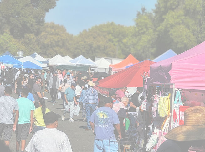 Crowded outdoor market with various tents and shoppers browsing The Market At Delta