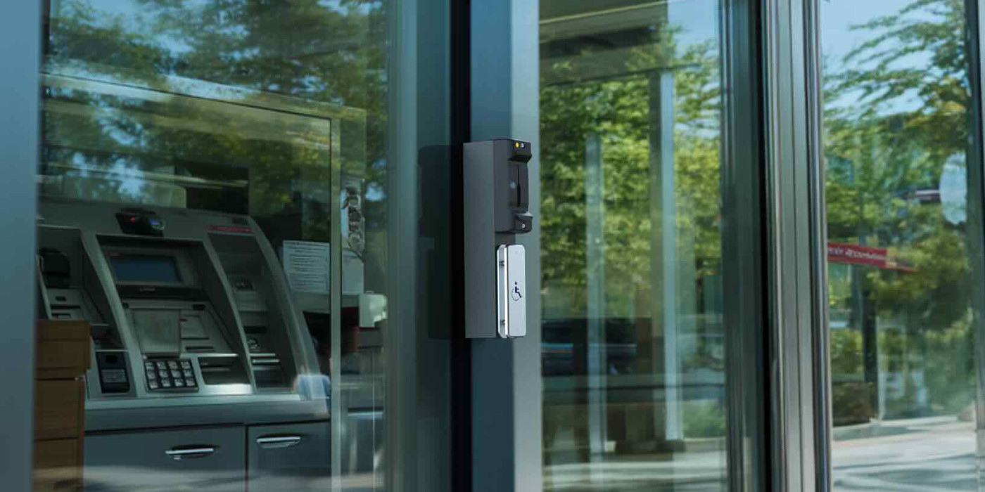 Glass door entrance equipped with surface-mounted access control reader for secure facility entry.