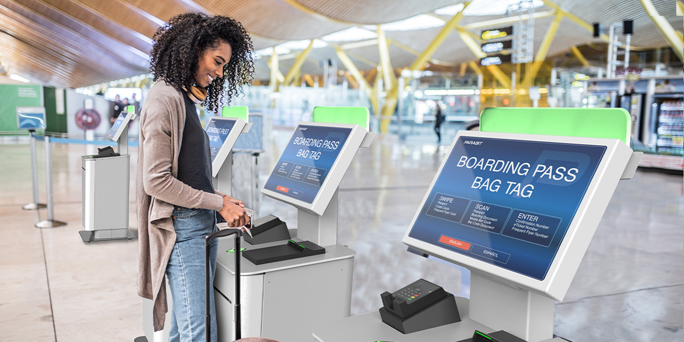 Woman using airport check-in kiosk to print boarding pass and bag tag