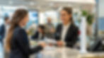 a person at a receptionist counter holding a piece of paper, speaking to another person, with a parabit counter camera housing on the counter