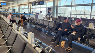 Parabit Seatback charging stations placed on the backs of seating in an airport termini with people sitting in the seats