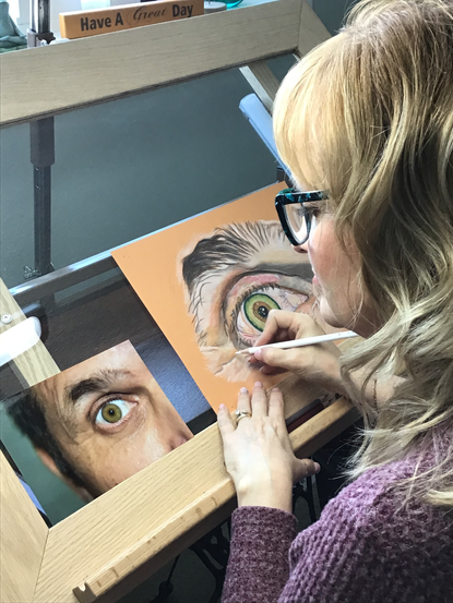 Lisa Lammi at the art easel drawing an eye with a coloured pencil.