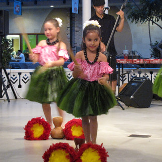 Young Hawaiian girls dancing in grassskirts and colourful blouses
