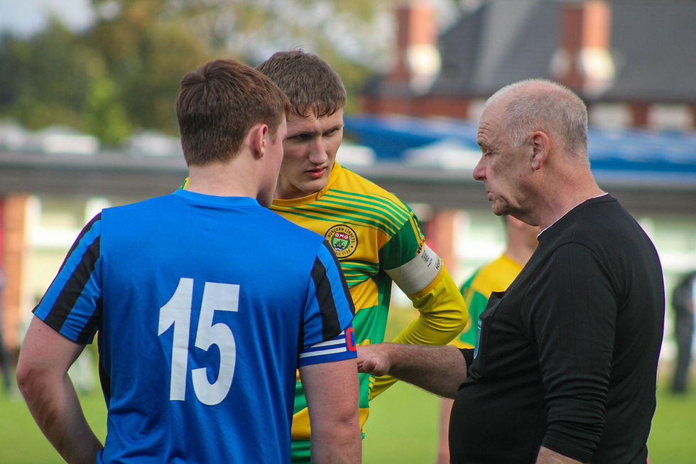The referee brings together the two captain's to have a word. Two-goal Lewis Crane was Linnets' skipper for the day.