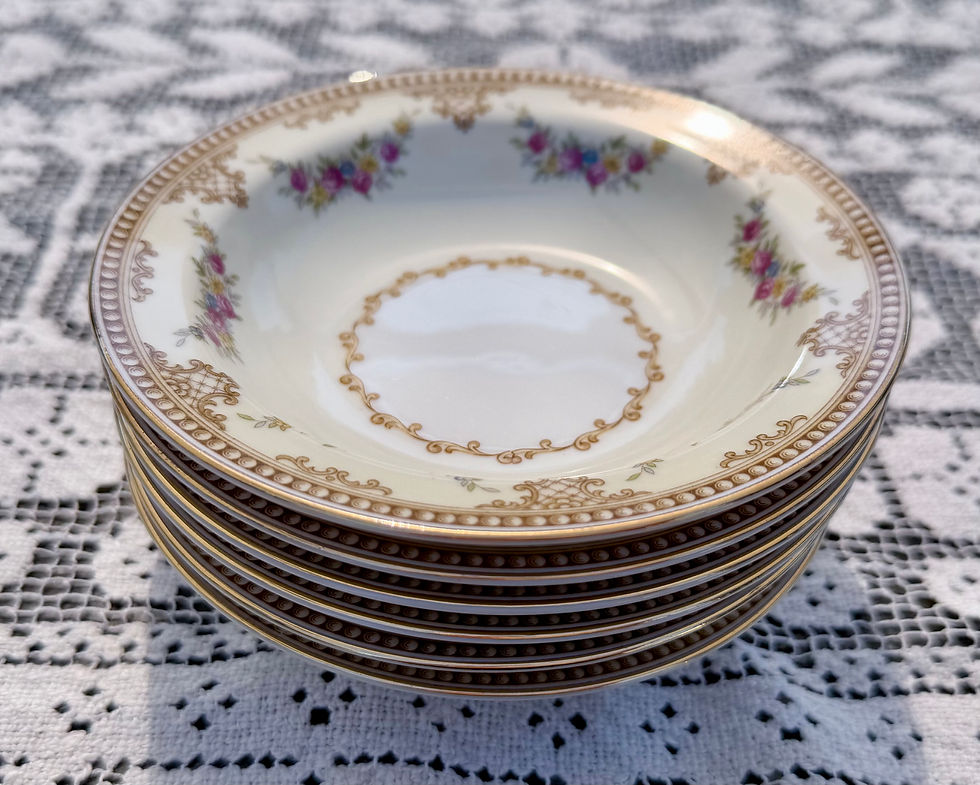 Stack of cream bowls with intricate gold and floral design