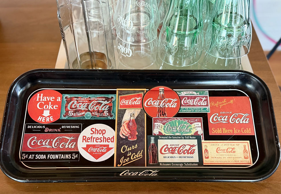 Black tray with diverse vintage Coca-Cola ads and logos