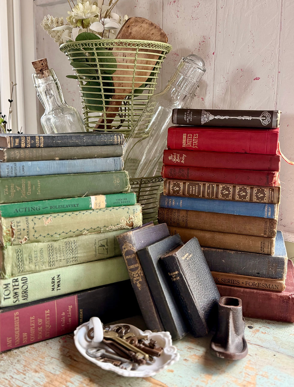 Stacks of vintage books in blue, green, and red with old keys