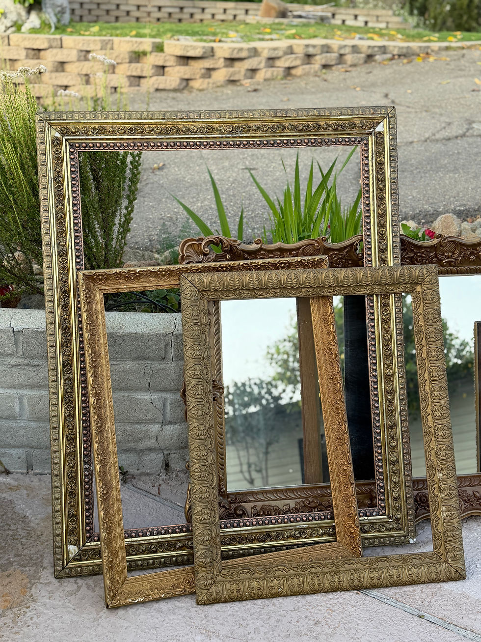 Several ornate gold frames and mirrors outdoors