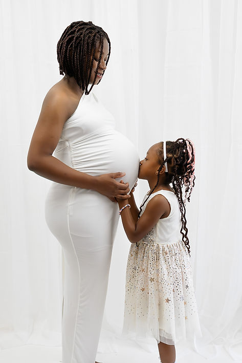 Minimalist maternity studio photography session in Barnsley - little girl kissing baby bump - maternity photos barnsly