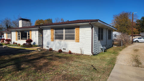 White residential house with brown shutters and a driveway