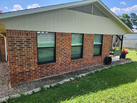Brick home exterior with installed vinyl window units – P-Tek