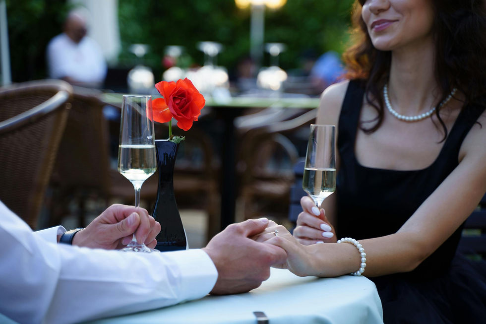 A couple’s hands reaching across a candlelit table during a romantic dinner.