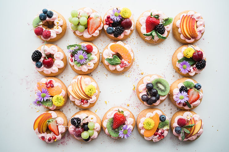 cupcakes decorated with icing and fresh fruits