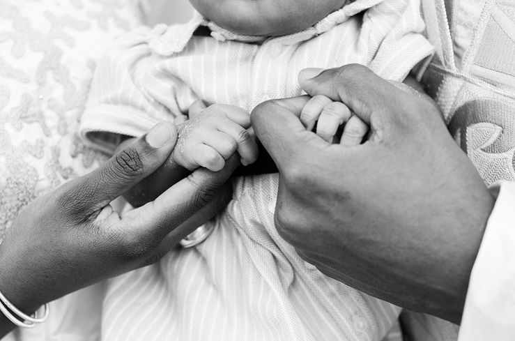 Photo couple qui prend bébé dans les bras