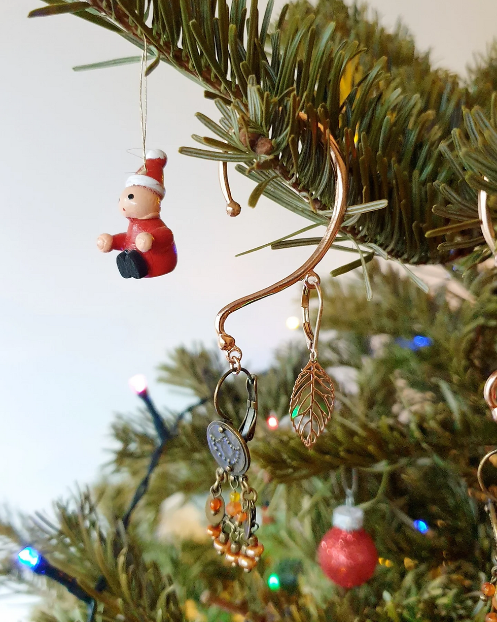 Bijou No-clip suspendu dans un sapin de Noël, symbole d’un cadeau élégant et innovant pour les fêtes.