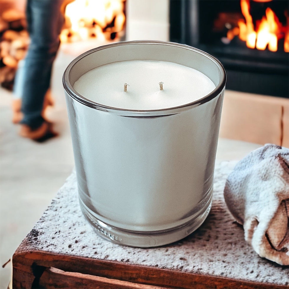 White candle with two wicks by a fireplace