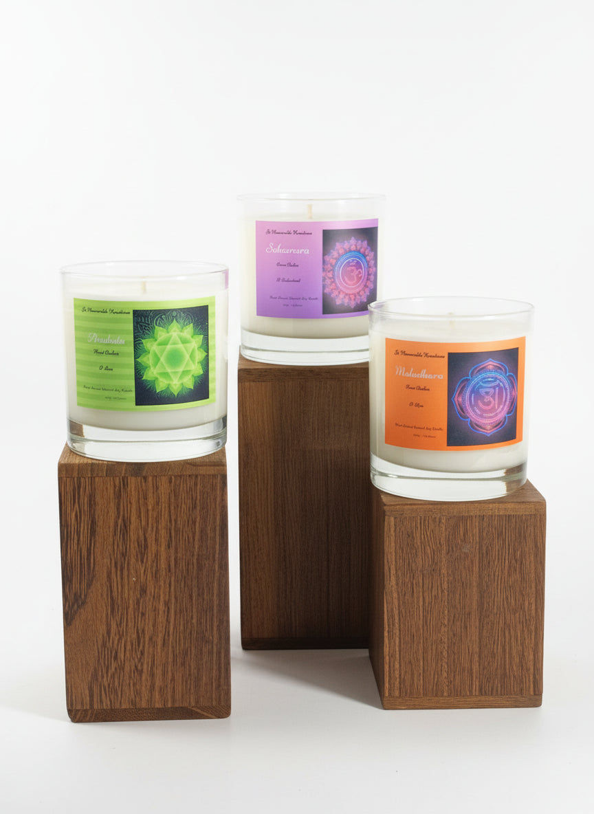 Three jar candles with colorful labels on wood blocks