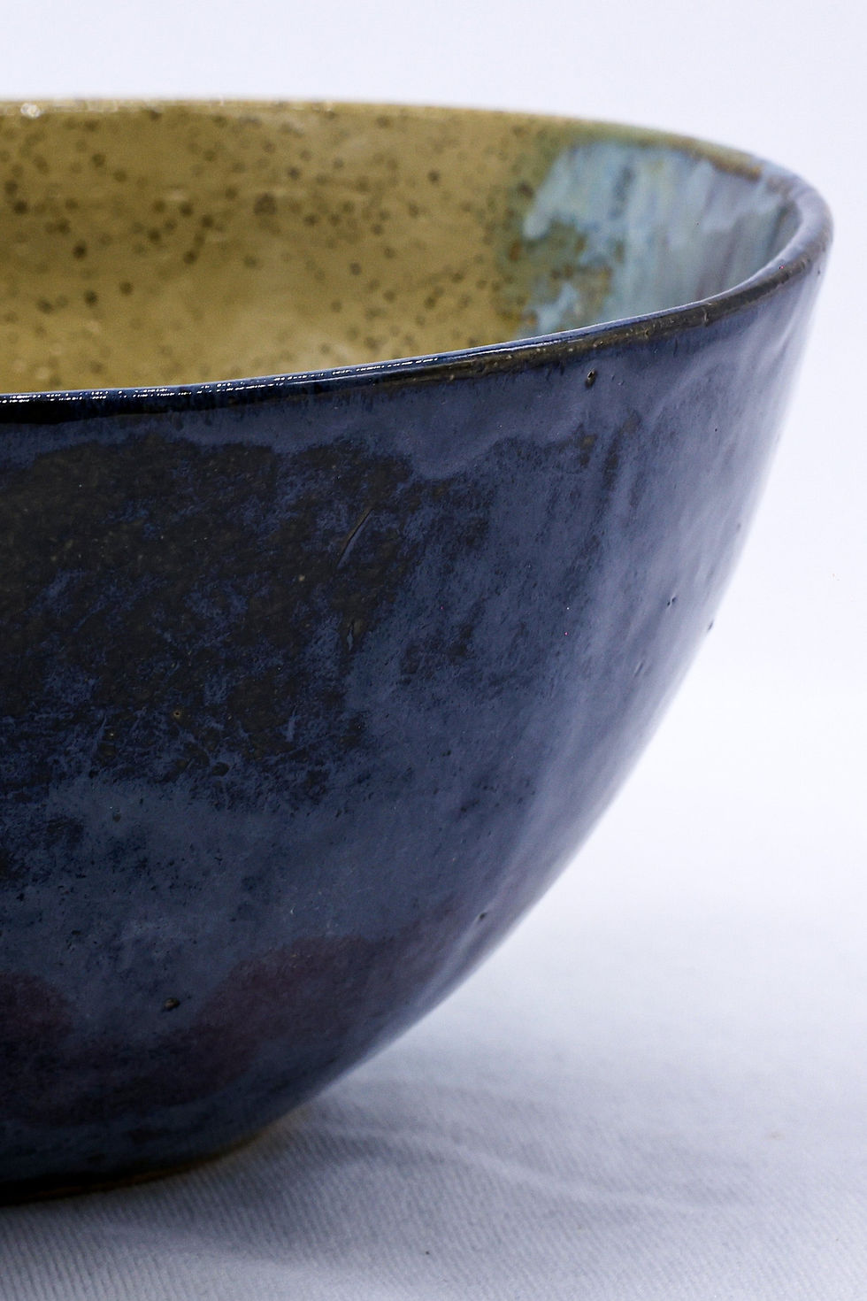 Close-up of textured bowl with dark blue and green glaze