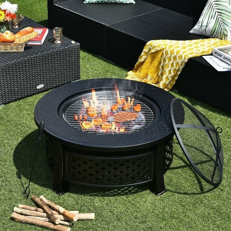 Outdoor fire pit grilling food on grass
