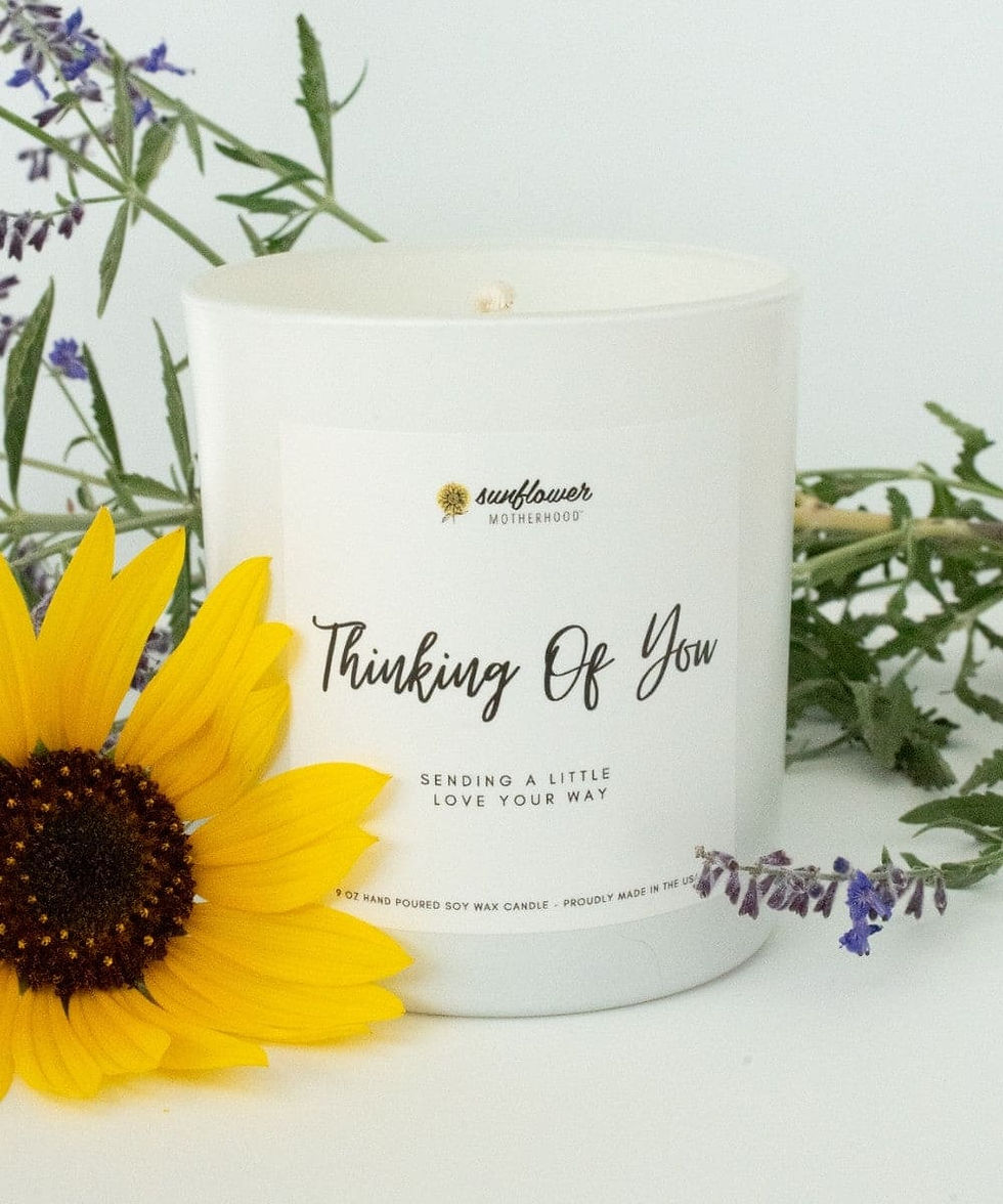White candle with 'Thinking Of You' text, sunflower, and lavender