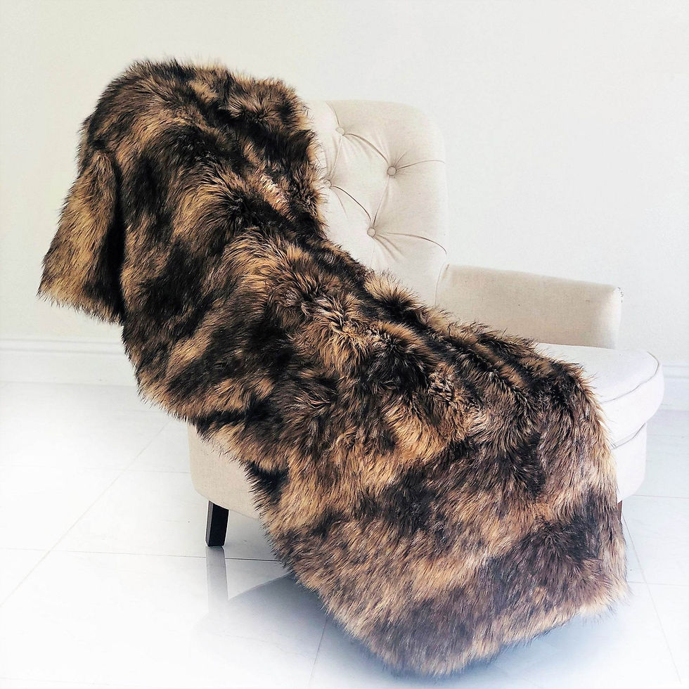 Brown and black faux fur blanket draped over a white armchair