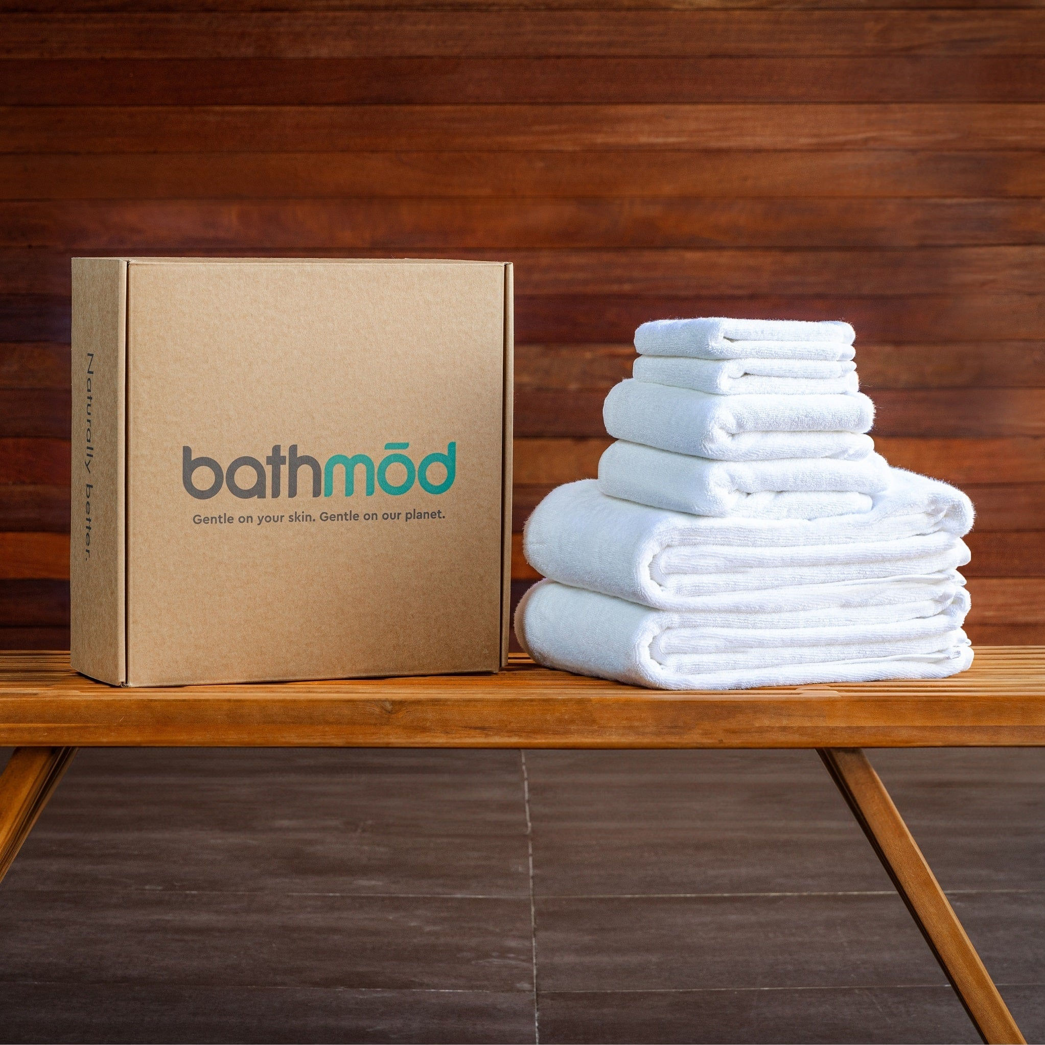 Bathmöd branded box next to a stack of white folded towels