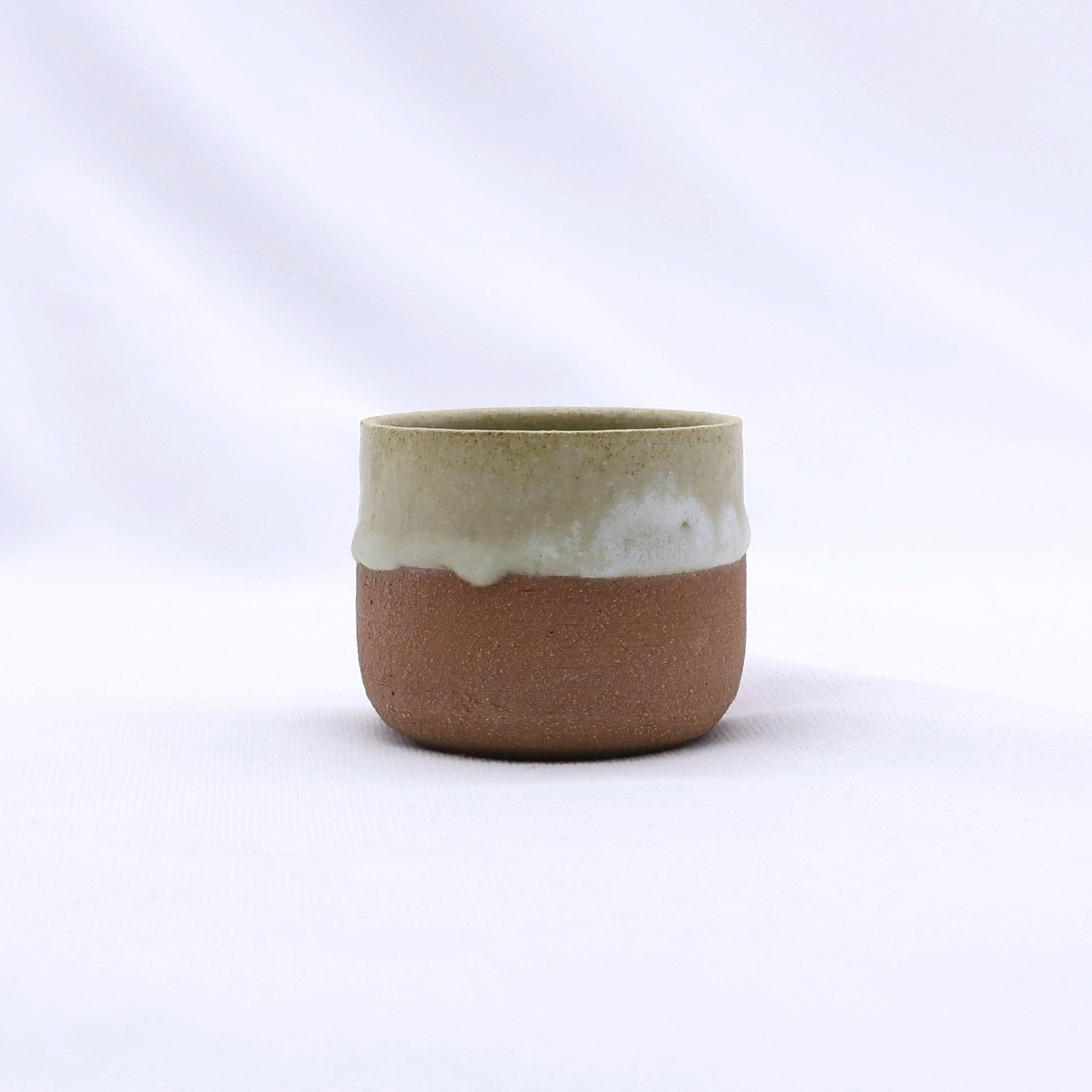 Handcrafted ceramic cup, brown with creamy white glaze