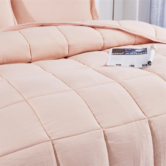 Pink quilted comforter with a magazine