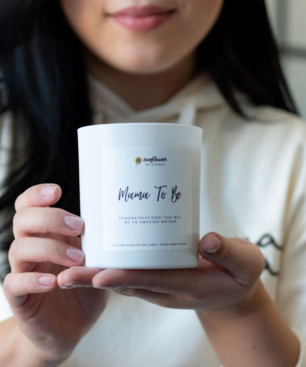 Person holding a white Mama To Be candle