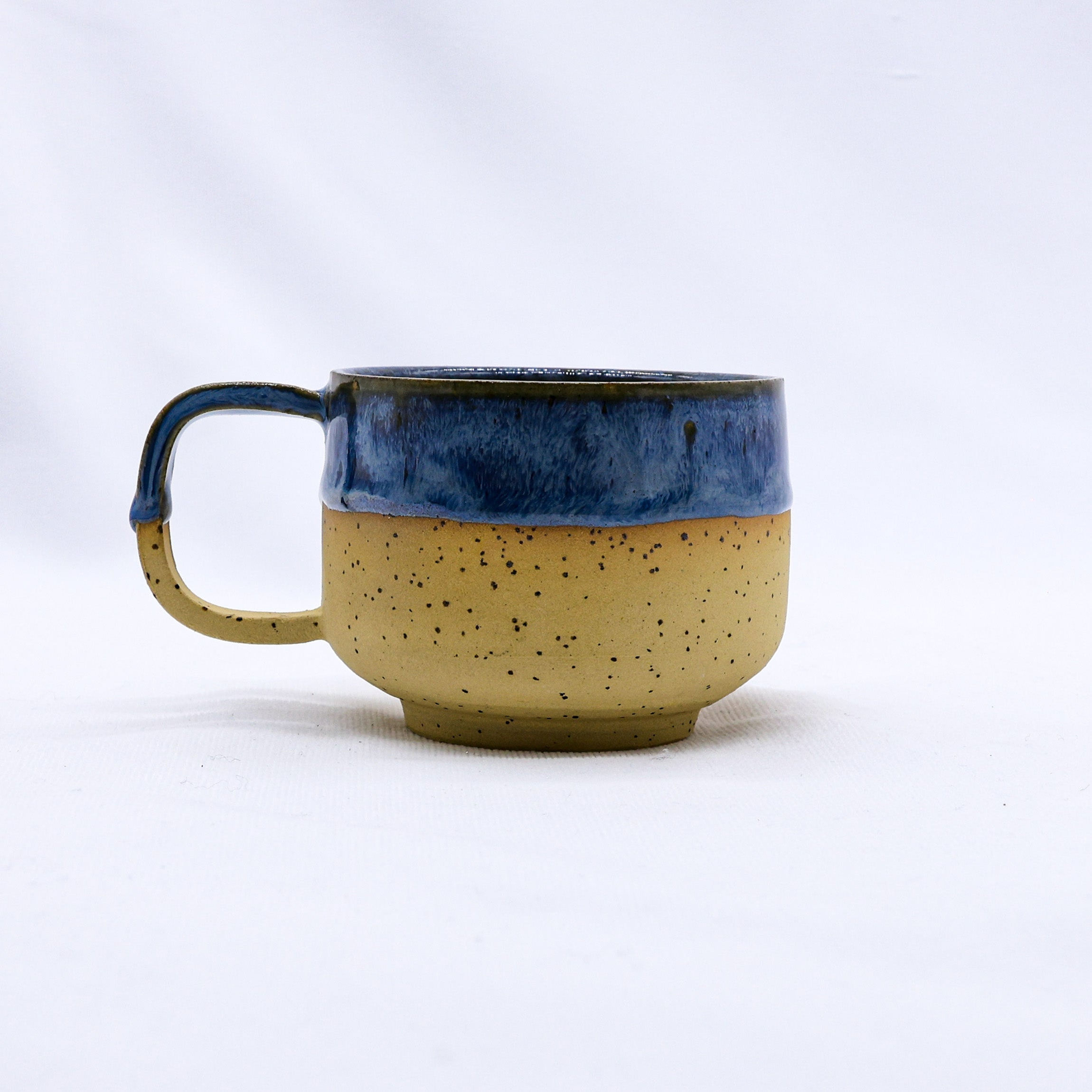 Ceramic mug, blue rim and speckled tan base