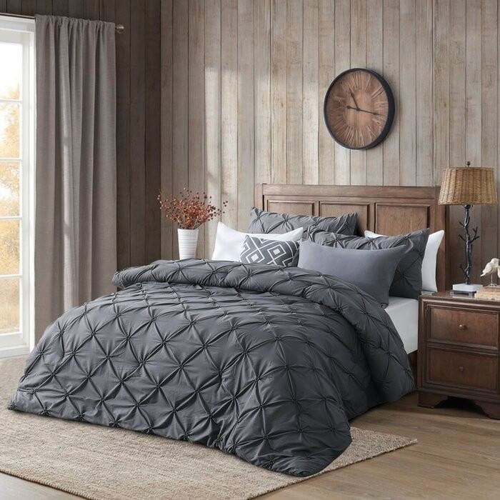 Bed with dark gray ruched bedspread in a cozy bedroom