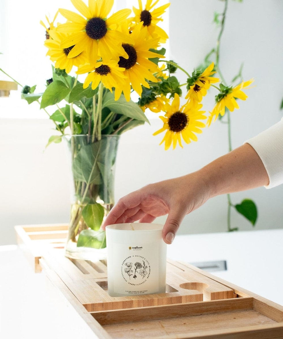 Hand placing candle on bath caddy with sunflowers