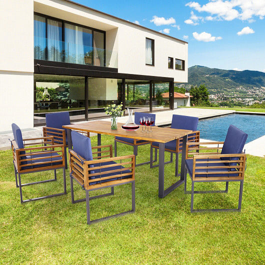 Outdoor wooden dining set with blue cushions by a pool