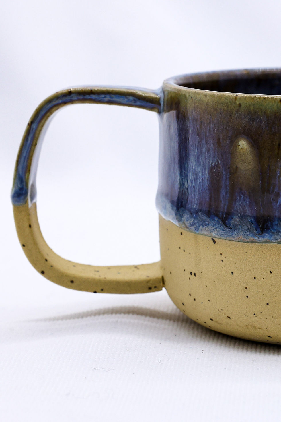 Handmade blue and tan ceramic mug with square handle