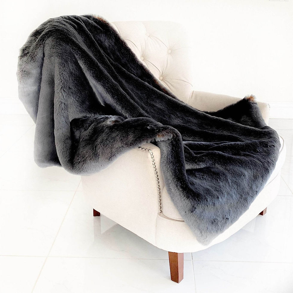Dark gray faux fur blanket on white tufted armchair