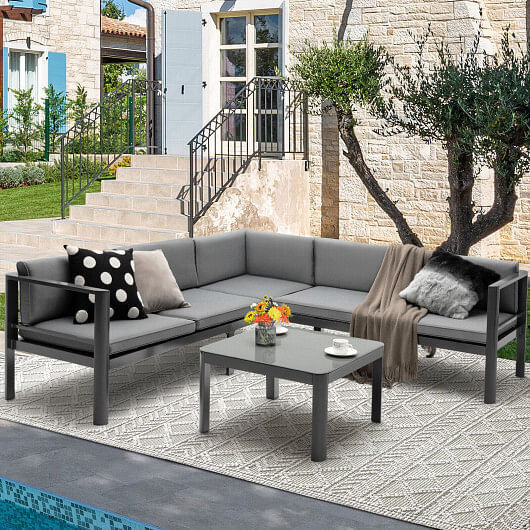 Gray aluminum patio furniture set with coffee table by pool.
