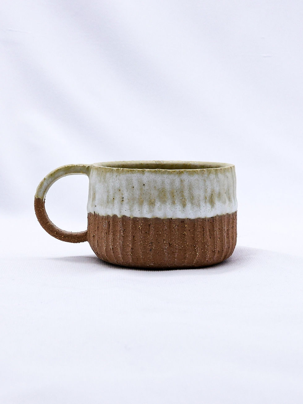 Textured ceramic mug, brown base, white glaze