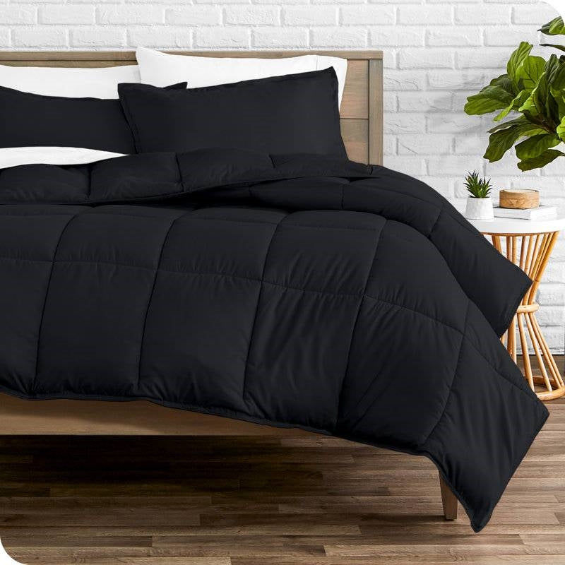 Black comforter and pillows on a wooden bed