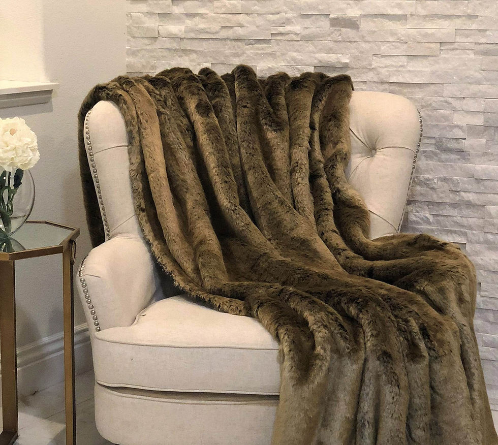 Luxurious brown faux fur blanket draped over a cream armchair