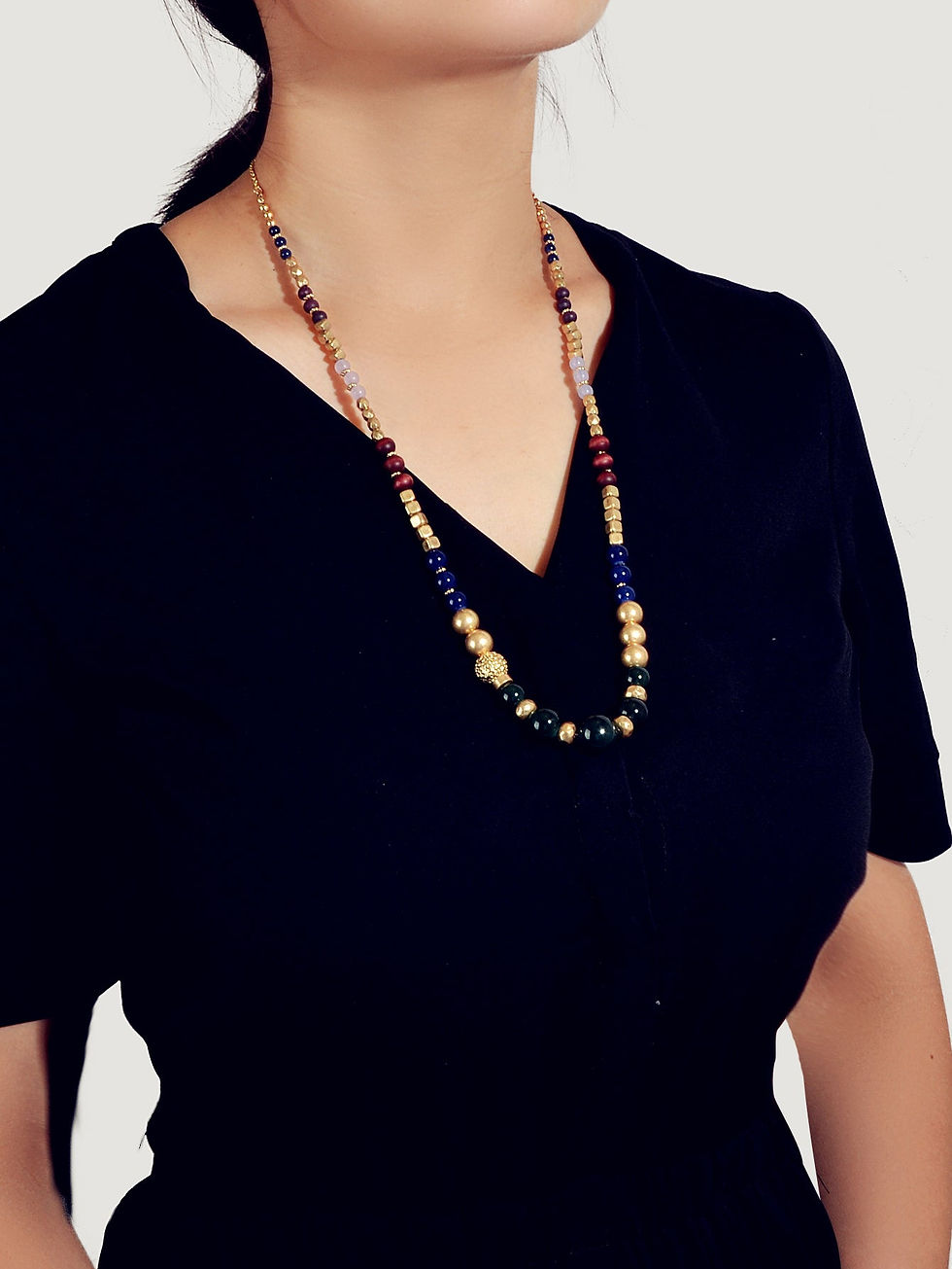 Long beaded necklace with blue, red, and gold beads