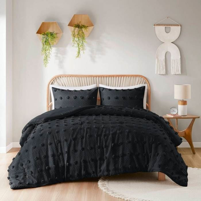 Bedroom with a bed featuring a black pom-pom comforter set