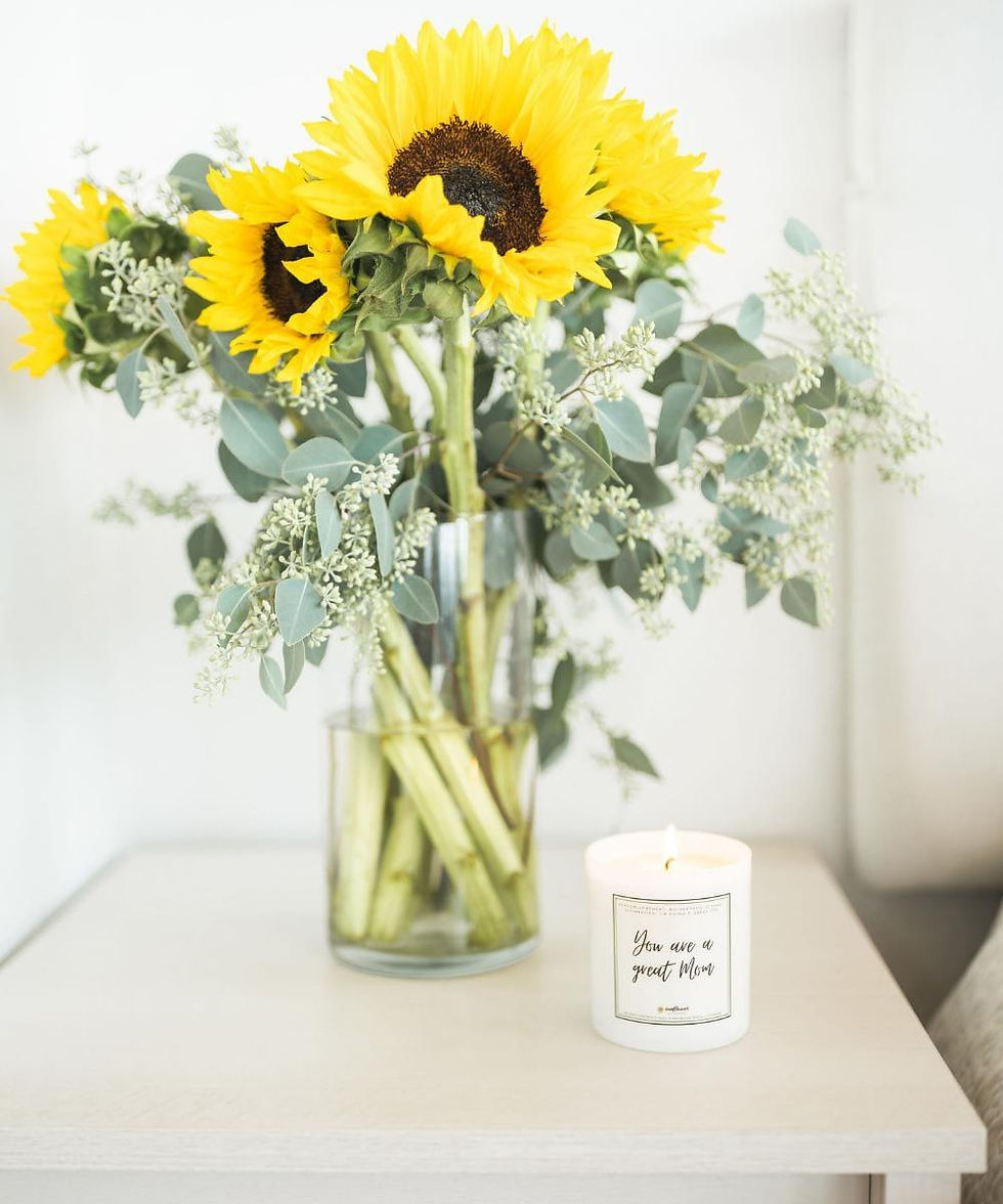Sunflowers in vase and lit candle with 'you are in a good place'