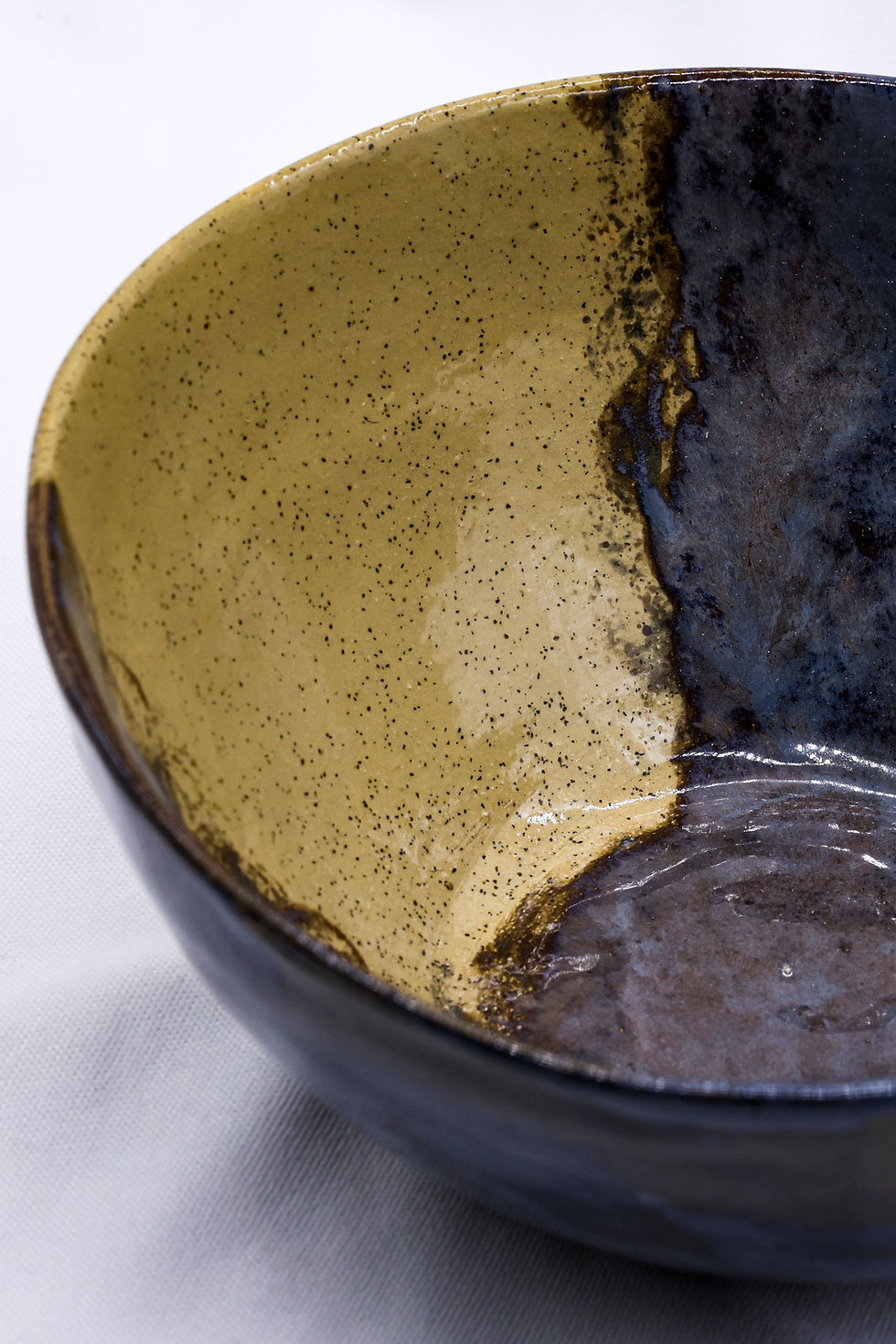 Handmade ceramic bowl with speckled gold and dark glaze