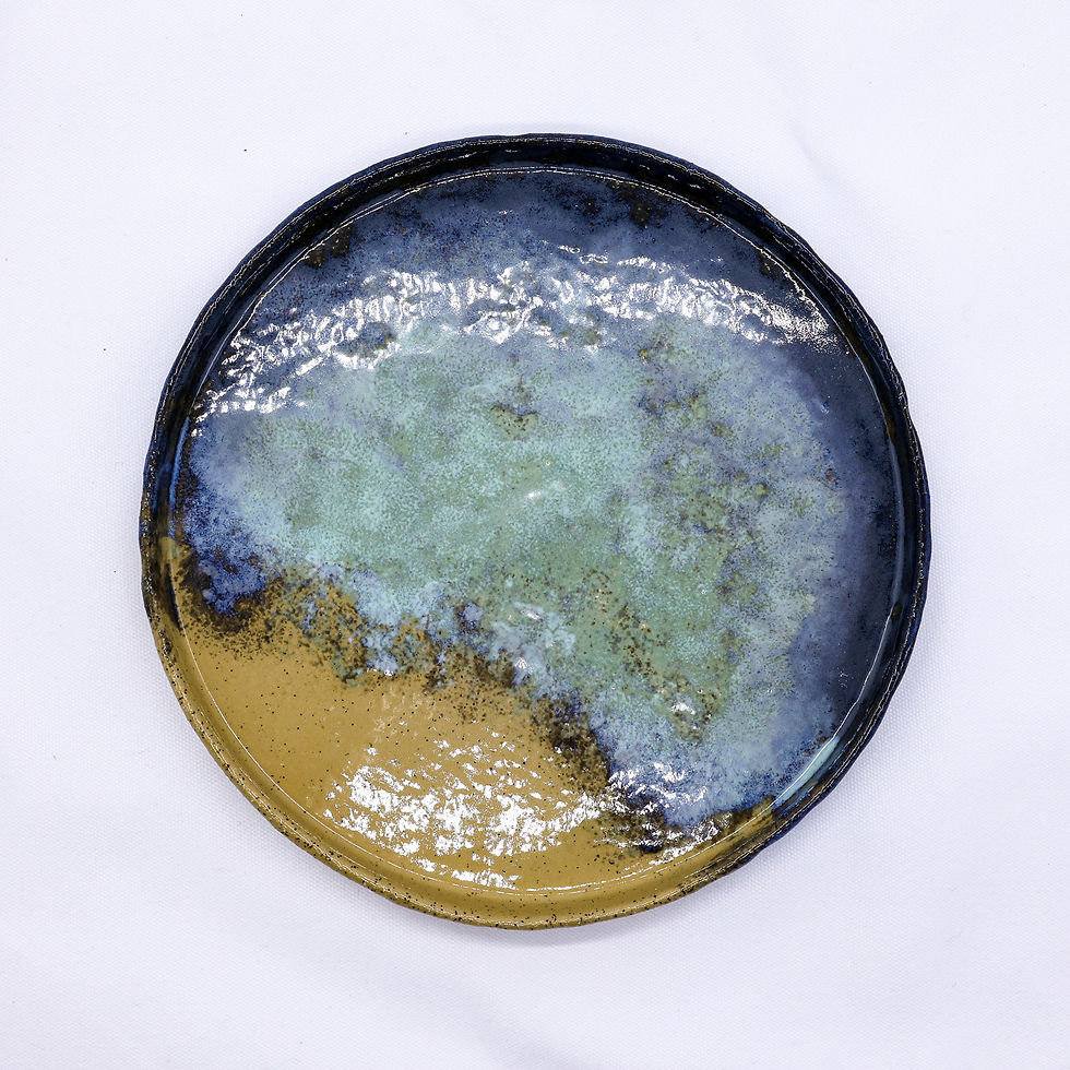 Round ceramic plate with blue, green, and gold glaze