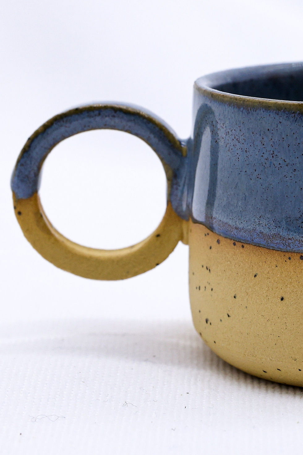 Two-toned blue and tan ceramic mug with handle