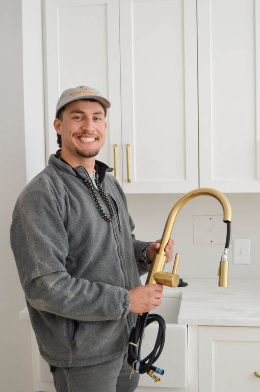 Professional plumber fixing a sink in a modern Charleston home.
