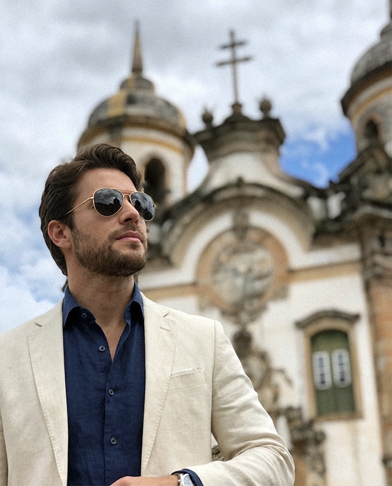Homem elegante em frente à igreja São Francisco de Assis, admirando a arquitetura barroca sob um céu de inverno