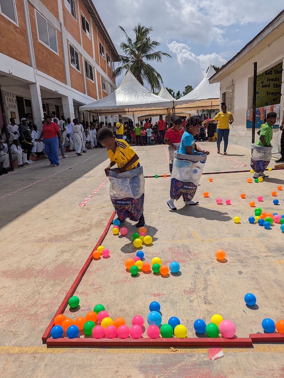 Children participating in a sack race at a Montessori school campus Accra.